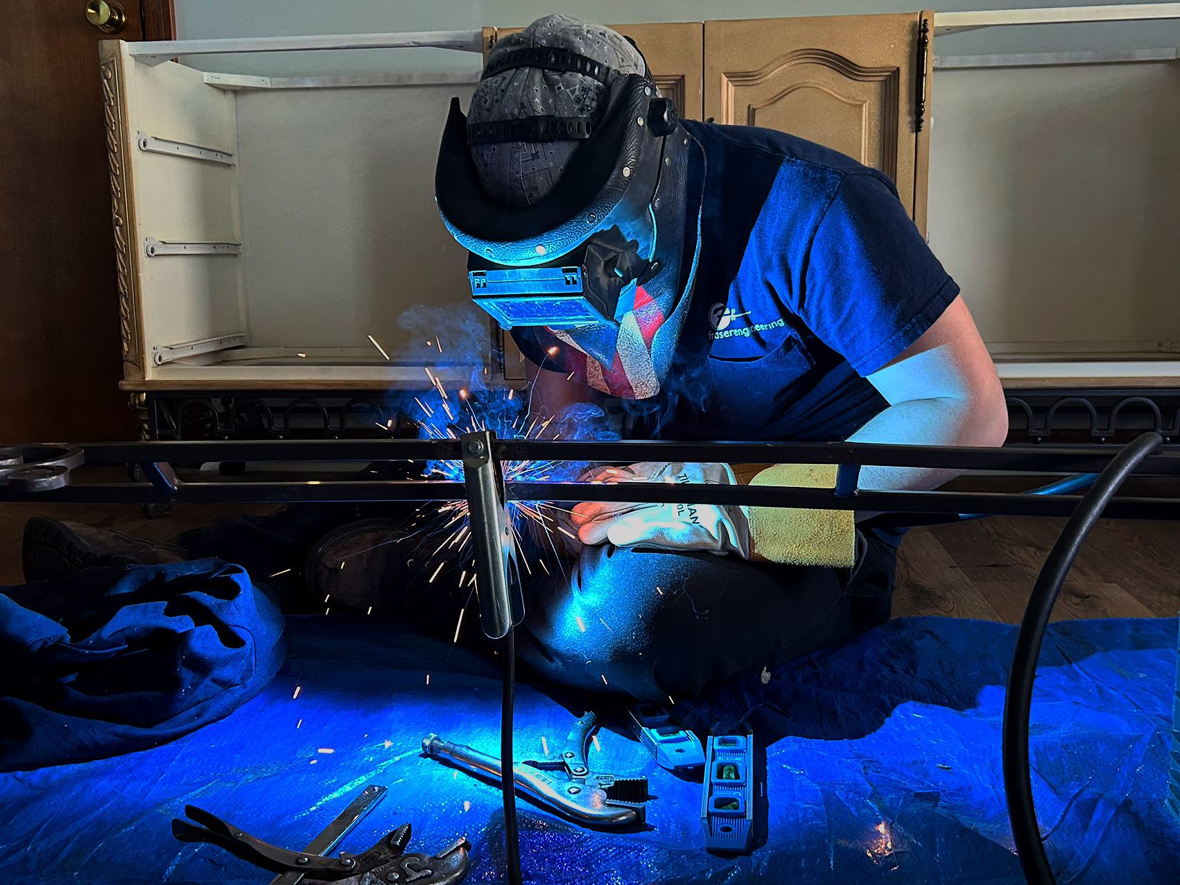 Welder fabricating a railing inside a home