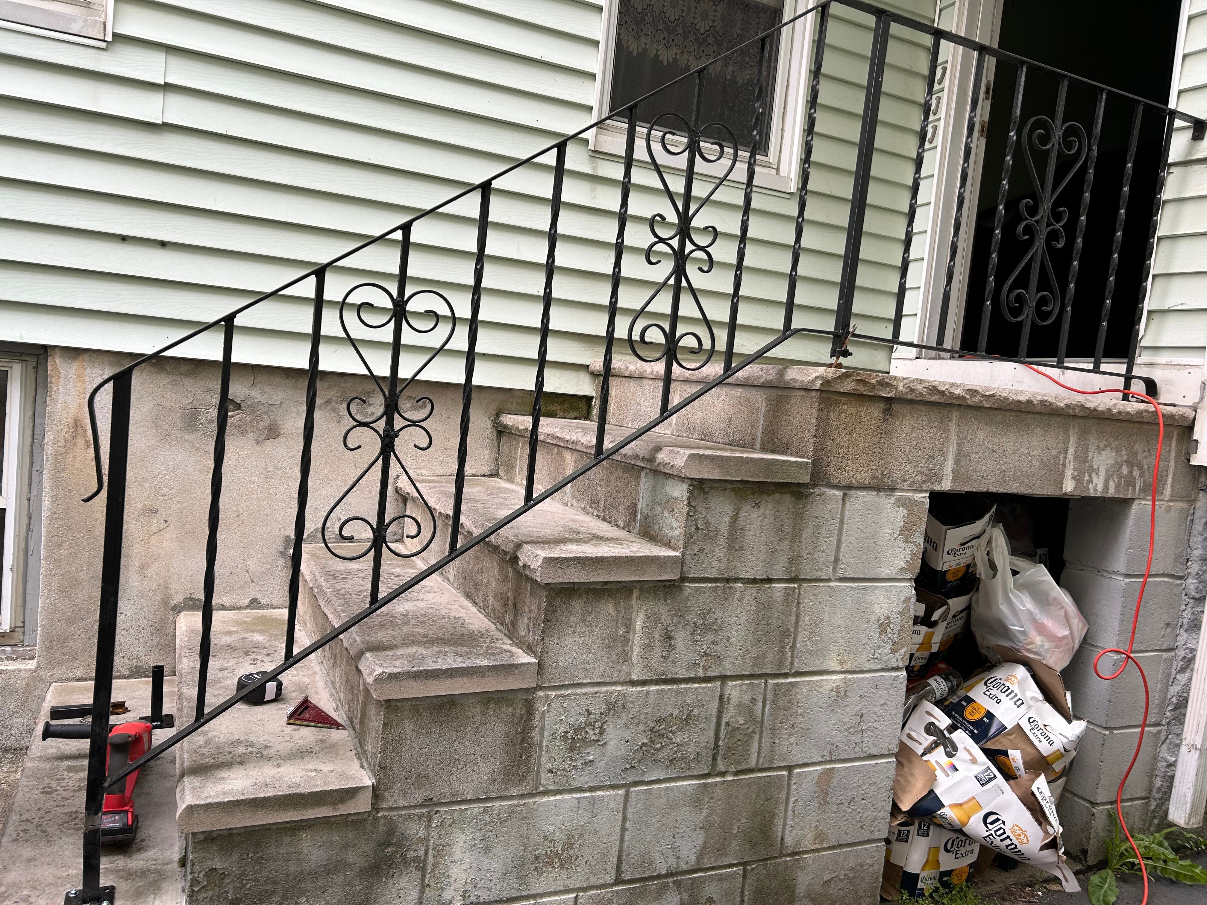 Ornamental wrought iron handrail fitted to concrete steps